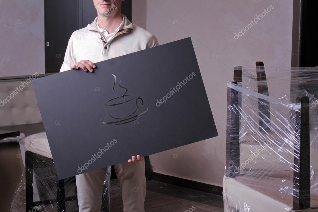Young businessman owner standing in unfinished restaurant cafeteria. Opening soon, starting own business, credits for small business development and launch.