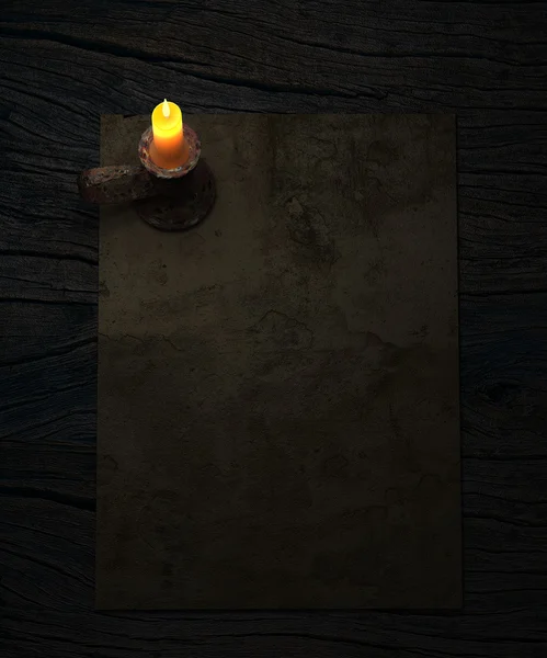 Background with old paper and candle on rustic wooden table. — Stock Photo, Image