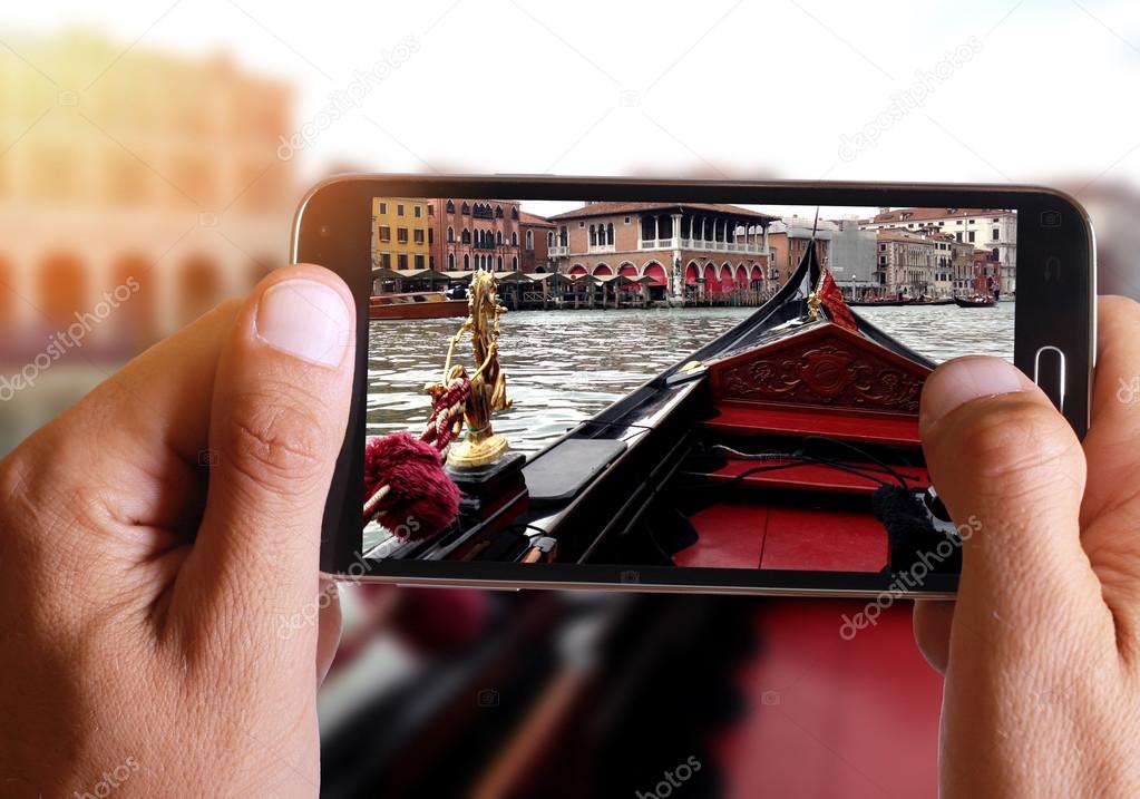 Male hand taking photo of Venice gondola with cell, mobile phone.