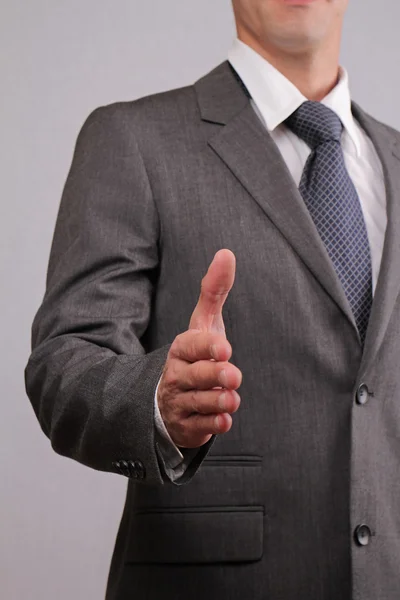 Close up of successfull businessman with open hand gesturing a hand shake. Meeting new business partners, partnership, negotiations, presentation — Stock fotografie