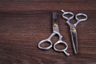 Stylish Professional Barber Scissors, Hair Cutting and Thinning Scissors on wooden background. Hairdresser salon concept. Haircut accessories