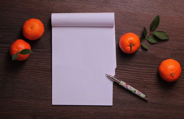 Mandarins and blank paper on wooden background, copy space image. Winter Time  and Christmas background, wish list and  new year goals — Stock fotografie