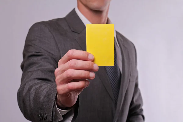 Gros plan d'un homme d'affaires montrant un carton jaune. Concept d'entreprise et de finance — Photo