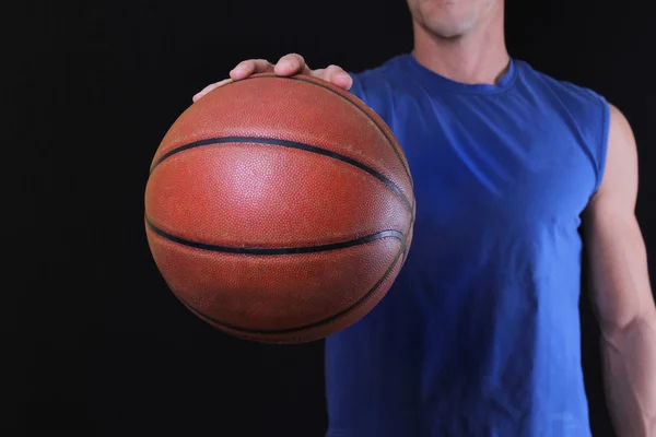 Close up of basketball player  man holding a basketball. Sport, active lifestyle concept