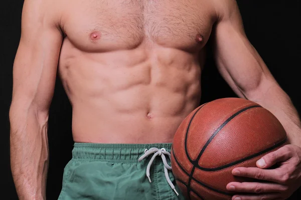 Primo piano di un uomo muscoloso che tiene una palla da basket. Sport, stile di vita attivo — Foto Stock