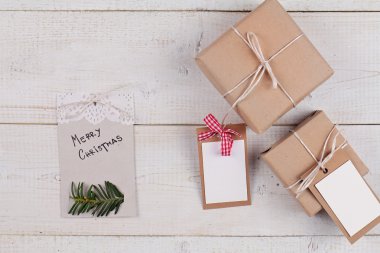 Noel vintage hediye kutuları beyaz rustik masada. Noel kopya alanı boş etiketleri ile sunar. Neşeli Noel tebrik kartı