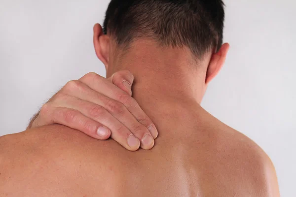 Un primer plano del hombre frotándose el doloroso cuello. Concepto de alivio del dolor —  Fotos de Stock