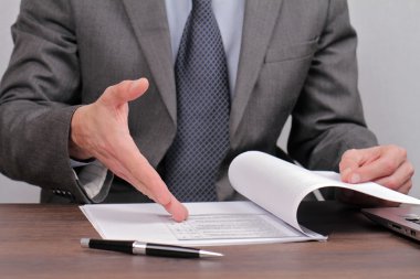 Businessman skeptical reading dokument close up. Lower disagree with agreement