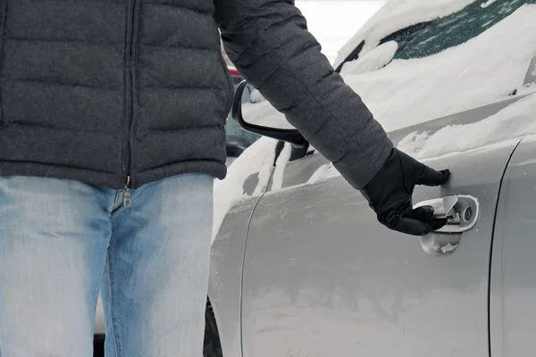 Homem segurando maçaneta da porta do carro coberto de neve. Conceito de condução segura inverno — Fotografia de Stock