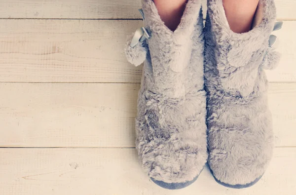 Woman wearing furry cozy boot slippers close up. Warmth concept. Winter clothes
