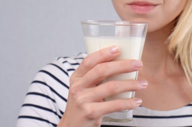 Bir bardak süt tutan kadın kapatın. Süt tarih seçici odak