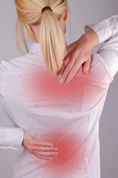 Женщина с болью в шее и спине. Деловая женщина потирает свою болезненную спину. Концепция обезболивания — стоковое фото