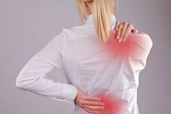 Woman with neck / back pain. Business woman rubbing her painful back close up. Pain relief concept — Stock Photo, Image