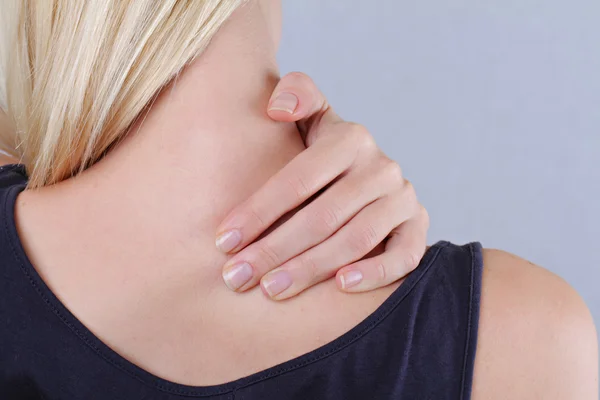 Femme avec douleurs au cou et au dos. Femme frottant son dos douloureux de près. Concept de soulagement de la douleur — Photo