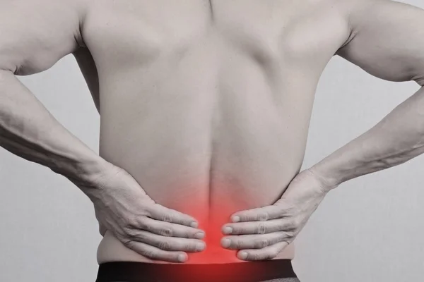 Mann mit Rückenschmerzen. Mann reibt seinen schmerzenden Rücken aus nächster Nähe. Schmerzlinderungskonzept — Stockfoto