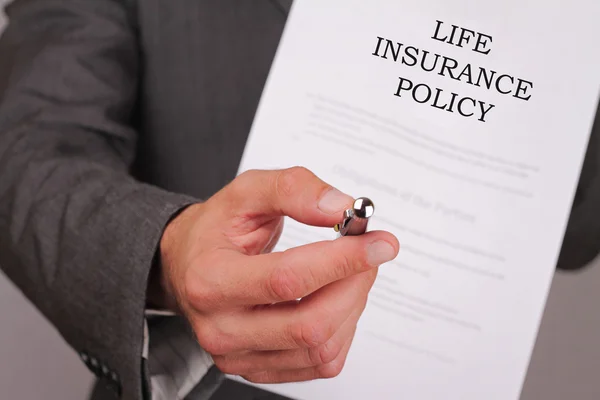 Concepto de seguro de vida. Hombre ofreciendo un bolígrafo para firmar la política de cerca . — Foto de Stock