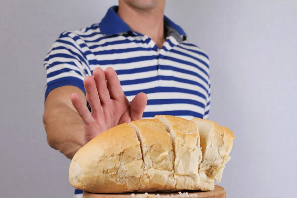 Gluten Hoşgörüsüzlük ve diyet kavramı. Adam beyaz ekmek yemeyi reddediyor. Seçici odak ekmek üzerinde — Stok fotoğraf