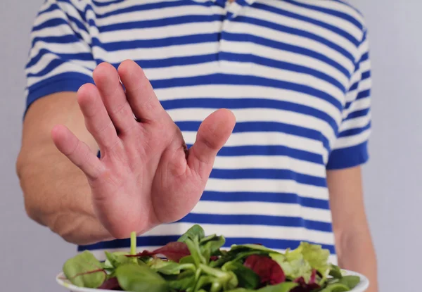 El hombre se niega a comer verduras de ensalada —  Fotos de Stock