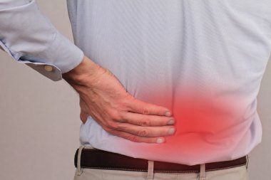 Business man holding his lower back.  Pain relief concept 
