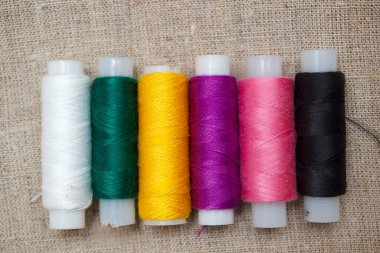 Masanın üzerinde çok renkli iplik makaraları yakın plan