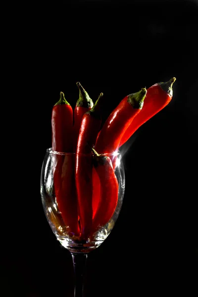 暗い背景にガラスの赤唐辛子 — ストック写真