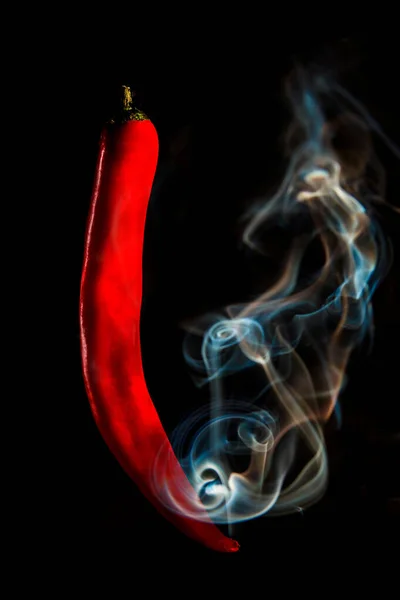 Pimenta vermelha fumegante em um fundo escuro — Fotografia de Stock