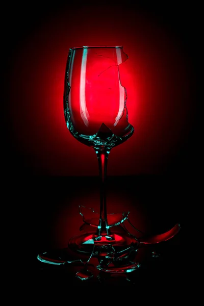 Křišťálové víno sklo roztříštěné na kousky na červeném pozadí — Stock fotografie