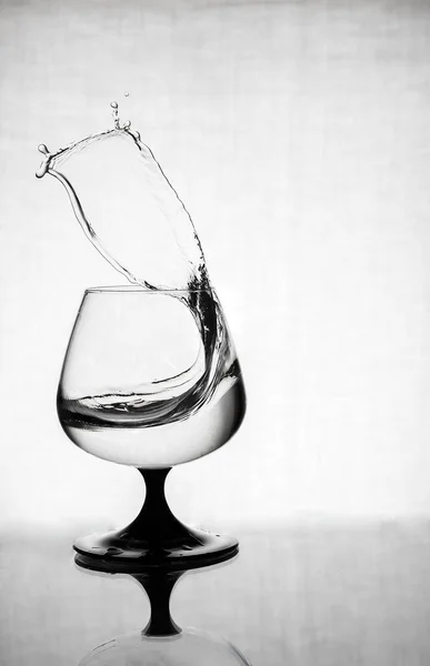 Salpicos de água em um copo de vidro — Fotografia de Stock