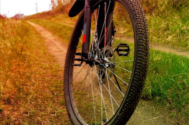 Toprak bir yolda disk frenleri olan bir bisiklet tekerleği.