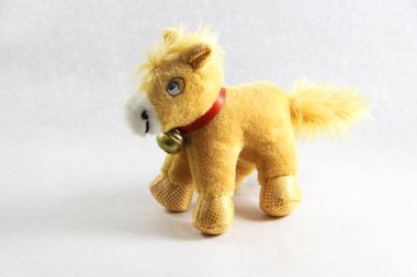 Beyaz arka planda kırmızı yakalı oyuncak at