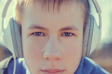 Genç adam konserde mızıka çalıyor.