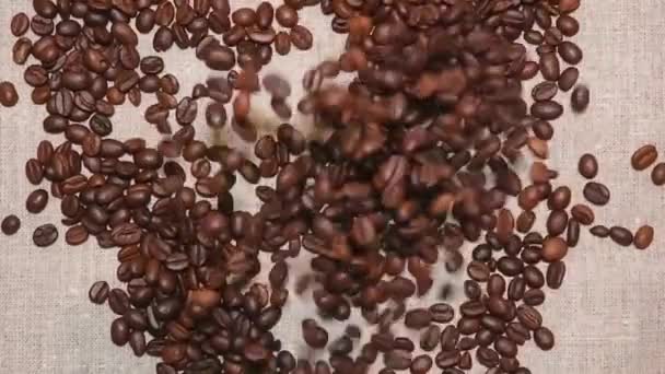 Zpomal. Kávová zrna padající na stůl — Stock video
