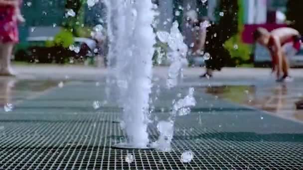 En cámara lenta. Fuente en el parque. Niños corriendo por la fuente — Vídeo de stock