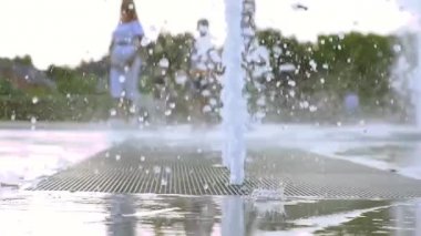 Ağır çekim. Parktaki çeşme. Çeşmede koşan çocuklar