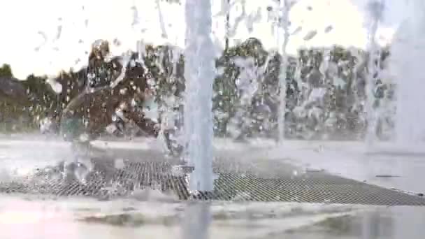 Zeitlupe. Brunnen im Park. Kinder rennen durch den Brunnen — Stockvideo