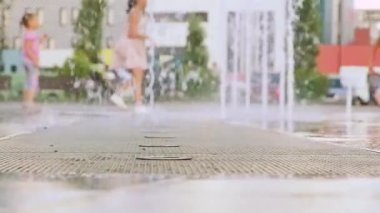 Ağır çekim. Parktaki çeşme. Çeşmede koşan çocuklar