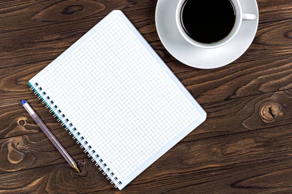 Notizbuch und Kaffeetasse auf einem Holztisch. Hintergrund. Design. Unternehmen — Stockfoto