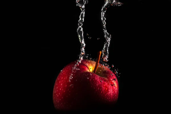 Una manzana cayendo al agua con salpicaduras y burbujas. Fruta. Sanidad —  Fotos de Stock