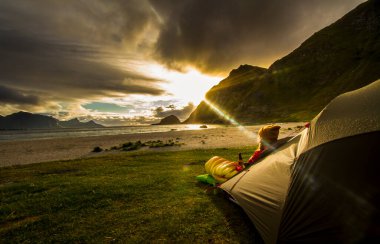 Lofoten 'da günbatımının tadını çıkaran kadın