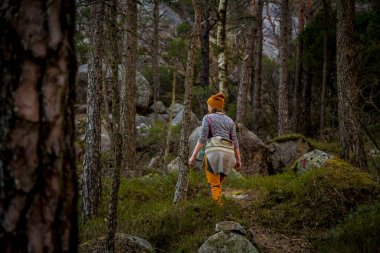 Kırmızı yapraklarla dolu bir sonbahar birikintisinde bir ağaç yansıyor.