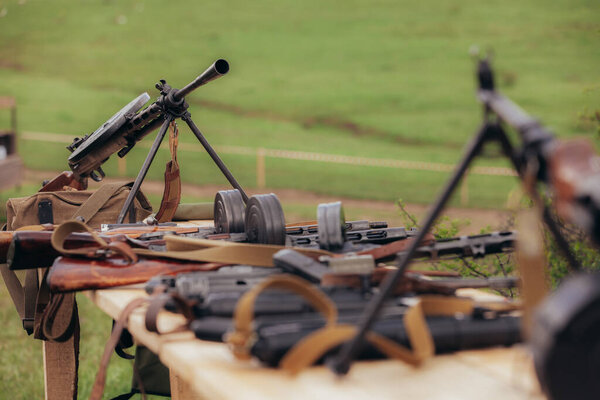 Two Diagterev submachine guns stand opposite each other on a table during the reconstruction