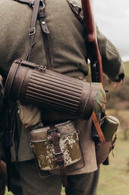 Muharebelerin yeniden yapılandırılması sırasında elinde matara ve tüple asker üniforması giyen bir adam.