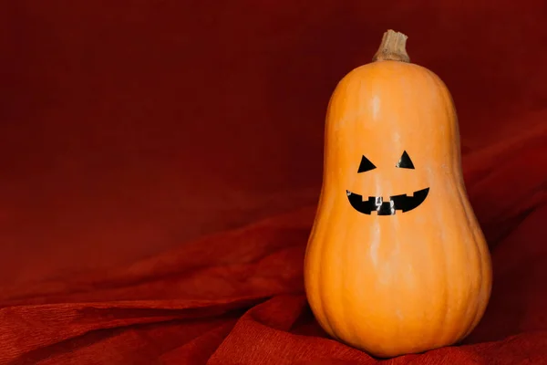 Тыковка с веселым лицом на Хэллоуин на красном фоне — стоковое фото