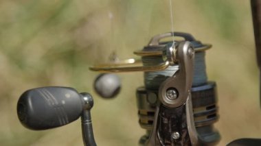 Balık tutmadan önce dönen bir bobin. Olta ağacın yanındadır. Yakın plan.