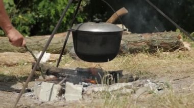 Yürüyüş sırasında kamp ateşinde yemek pişirmek.