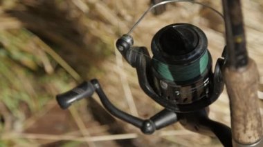 Balık tutmadan önce dönen bir bobin. Olta ağacın yanındadır. Yakın plan.