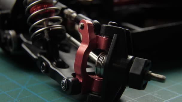 Close-up of radio control model suspension elements buggy car on cutting mat — Stock Video
