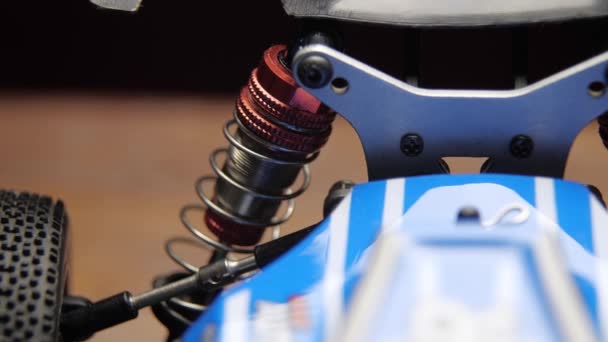 Close-up dari radio kontrol model suspensi elemen kereta mobil pada memotong tikar — Stok Video