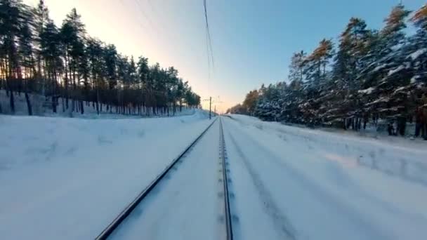 FPV dron görüntüsü. Gün batımında kış ormanında tren yolu üzerinde hızlı uçuş. — Stok video