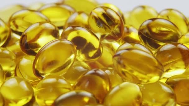 Tampilan makro omega 3 kapsul minyak ikan emas, latar belakang rotasi — Stok Video